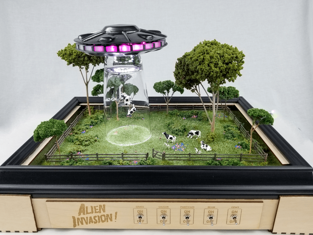 Alien Invasion sculpture by Jake Ashley featuring levitating cows and UFO