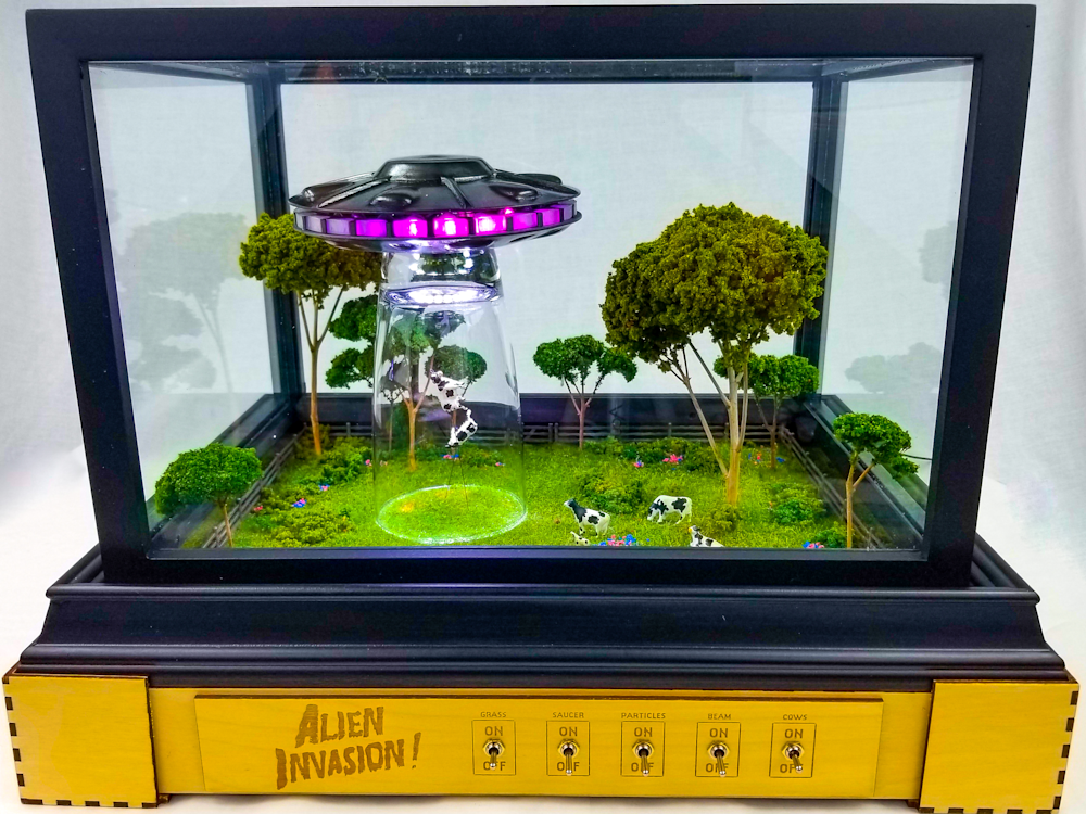 Alien Invasion sculpture by Jake Ashley featuring levitating cows and UFO